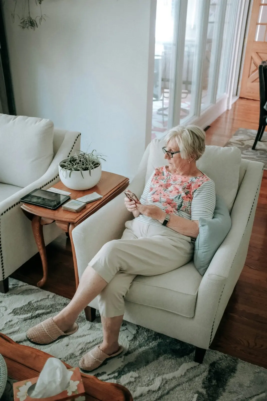A railroad retiree talking with a therapist by phone from a comfortable armchair at home