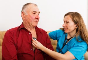 a woman using a stethoscope to check the heart of a man