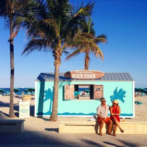 a man and woman sitting on a bench on a beach