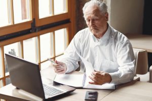 a man sitting at a desk with a laptop and papers