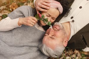 a man and woman lying on the ground with flowers