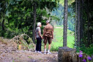 a man and woman holding hands in the woods