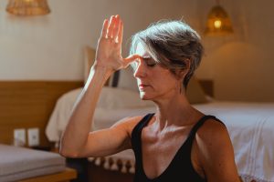 a woman holding her hand to her forehead