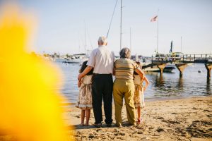 a group of people standing on a beach looking at boats