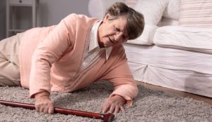 a woman lying on the floor with a cane