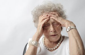 an old woman with her hands on her head