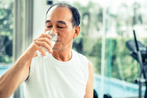 Senior man drink mineral water in gym fitness 