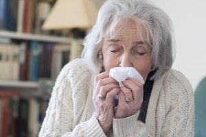 senior woman blowing nose