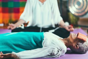 a woman lying on a yoga mat with her eyes closed