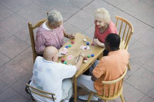 Senior people playing cards, smiling