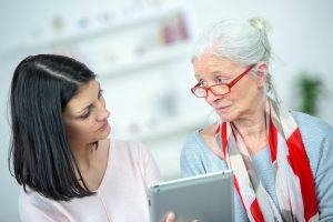 Helping old woman use a tablet computer