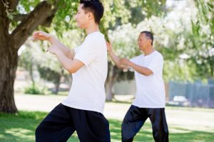 People practicing thai chi in park