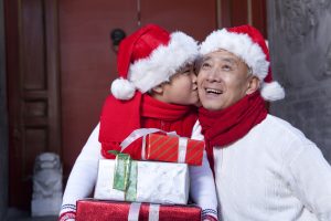 Grandpa and grandson holding Christmas Gifts