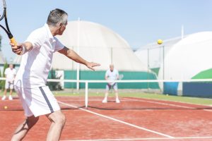 Man swinging tennis racket