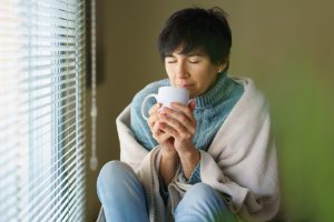 woman smelling coffee from her cup