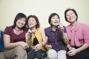 Senior Women Singing In Front Of Microphone