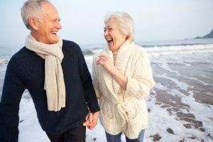 Senior Couple Walking Along Winter Beach