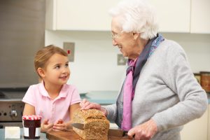 older adult slicing bread