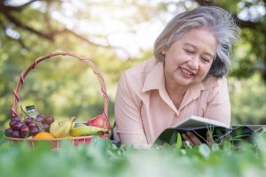 woman reading book and lying on the picnic mat 