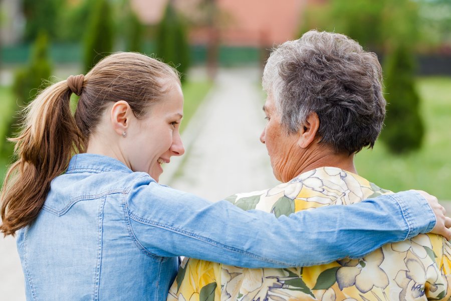 A woman wrapping her arm around her parent.